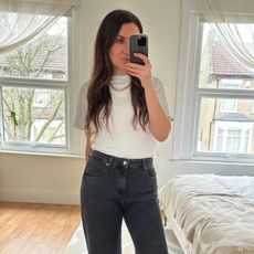 Woman wears white t-shirt, black jeans