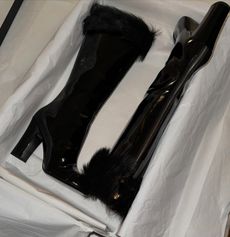 A photo of tall black boots in a box.