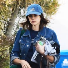 Kaia Gerber wearing a denim jacket and baseball cap