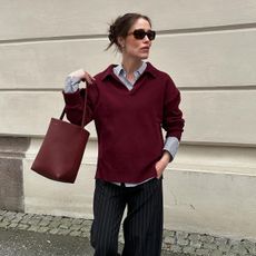 Woman wearing a burgundy sweater with a burgundy bag