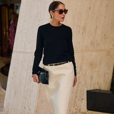 Woman in black sweater and white skirt